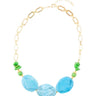 Necklace with gold chain and blue and green beads on a white background