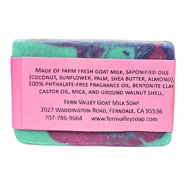 Bar of Floral Natural Goat Milk Soap with a pink label detailing ingredients and contact information on a white background