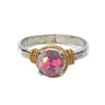 Ring with pink gemstone and gold and silver band on white background