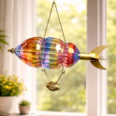 
Handblown Glass Airship Hot Air Balloon glass sculpture resembling a rocket with a gold base on a windowsill.