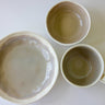 Three ceramic bowls of different sizes on a white background