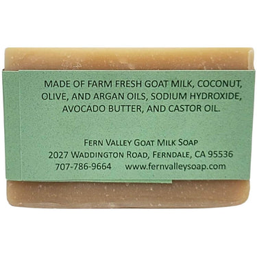 Bar of Handmade Goat Milk Shampoo Bar with a green label detailing ingredients and contact information on a white background