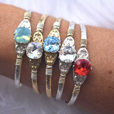 Set of five colorful gemstone bracelets on a wrist against a white background