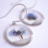 Necklace with a pendant featuring pressed flowers on a white background