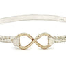 Silver bracelet with gold infinity symbol on a white background