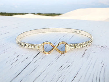 Gold bracelet with infinity symbol on a wooden surface