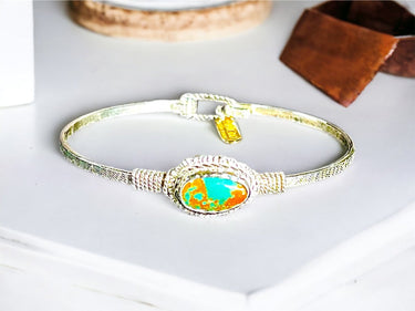 Bracelet with a turquoise and orange stone on a white surface