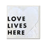 Heart-shaped sign with 'LOVE LIVES HERE' text on a white background