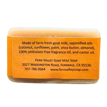 Bar of Masculine Goat Milk Shower Soap  with an orange label containing text about ingredients and contact information.