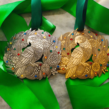 Two parrot-themed medals, one silver and one gold, on green ribbons.