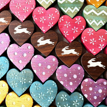 Colorful heart-shaped wooden tiles with various patterns and rabbit illustrations.