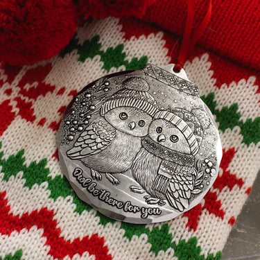 Silver pocket mirror with owl design on a red, green, and white patterned fabric background