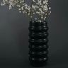 Black ribbed Ceramic Vase with white flowers against a dark background