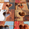 Wooden puzzle with heart-shaped holes on a textured surface