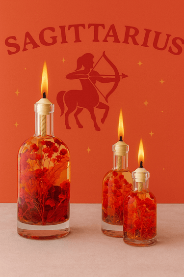 Three lit candles in bottles with red liquid and flowers against an orange background with a Sagittarius symbol.