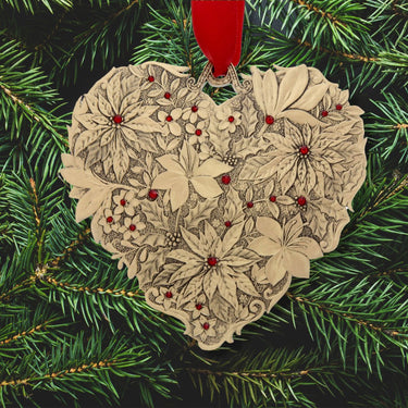 Heart-shaped floral ornament with red berries on a green pine branch