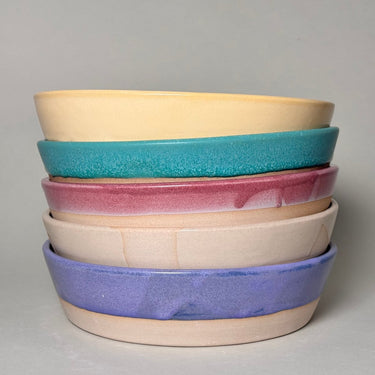 Stack of colorful ceramic bowls on a gray background