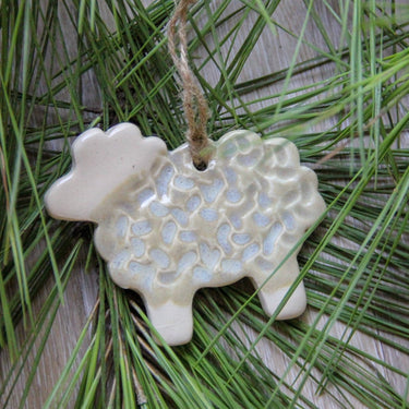 Ceramic snowflake ornament with textured surface on a green leaf background