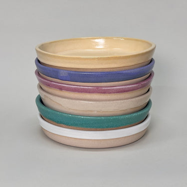 Stack of colorful ceramic bowls on a gray background