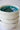 Stack of white ceramic bowls with a teal interior on a light gray background
