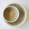 Two ceramic bowls, one inside the other, on a white background