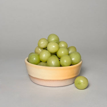 Green grapes in a ceramic bowl on a gray background