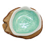 Ceramic bowl with green interior on a wooden base