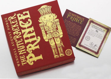 Red box with gold illustration of a nutcracker and text 'The Nutcracker Prince' on a white background.