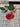 Red handcrafted porcelain rose with leaves on a textured surface