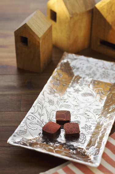 Decorative tray with chocolate truffles on a wooden surface