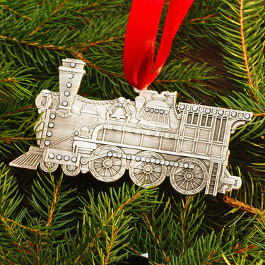 Silver train ornament on a green Christmas tree
