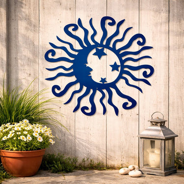 Decorative metal sun and moon wall art on a wooden wall with plants and a lantern.