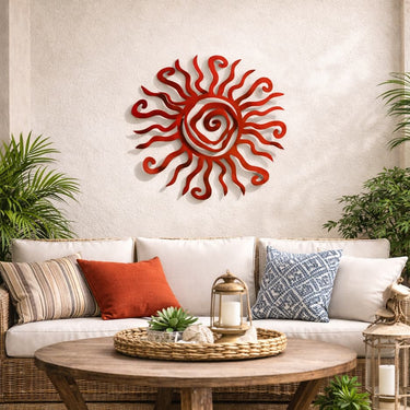 Decorative red sun wall art above a white sofa with colorful pillows in a living room setting.