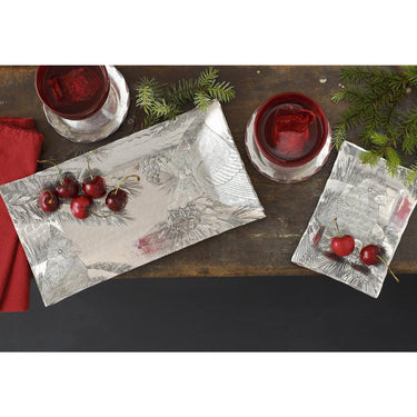 Decorative plates with cherries and red glasses on a wooden surface