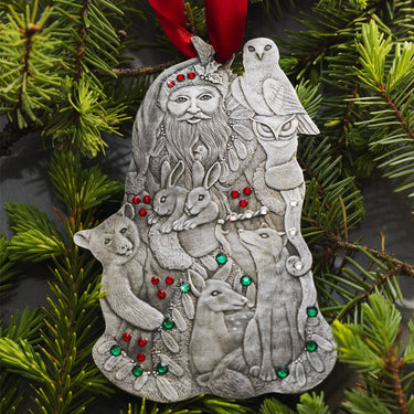 Decorative ornament with a figure surrounded by animals on a green Christmas tree.
